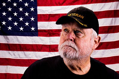 Vietnam veteran sits in front of US Flag