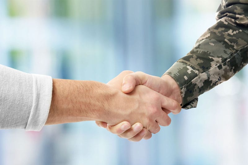 Service member and doctor shaking hands